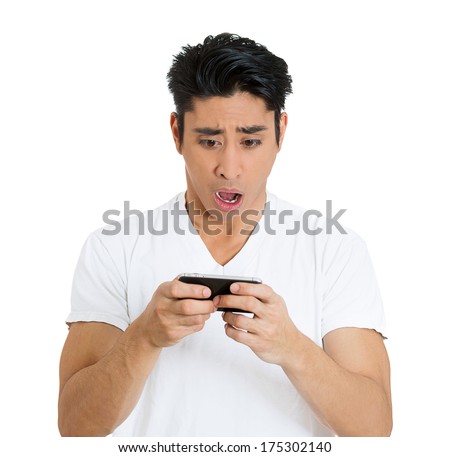 Closeup portrait of handsome young man, shocked surprised guy, opened mouth, eyes, by what he sees on his cell phone, isolated on white background. Negative human emotions, facial expressions, feeling