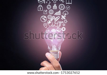 Qualification concept. Hand holds luminous bulb, symbols knowledge, graphics, settings and lock flow up from it, double exposure with futuristic symbols