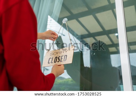 Woman closed store with sign board front door shop, Small business come back turning agian after the situation is resolved.