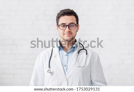 Online help and modern consultation remotely. Smiling male doctor in white coat and glasses, free space