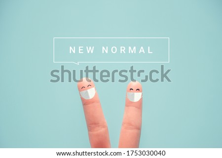 Fingers wearing protective mask and social distancing. with NEW NORMAL word, Adapting to new life or business post-lockdown after coronavirus pandemic.  Royalty-Free Stock Photo #1753030040