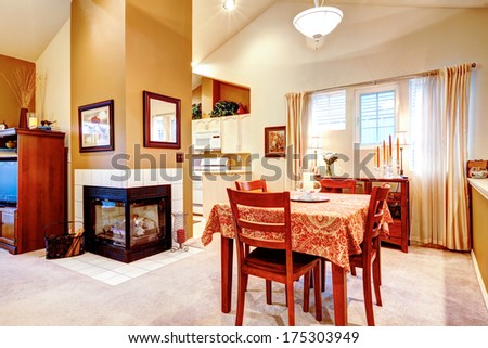 LIght tones dining and kitchen room with bright wood dining table set and cozy fireplace