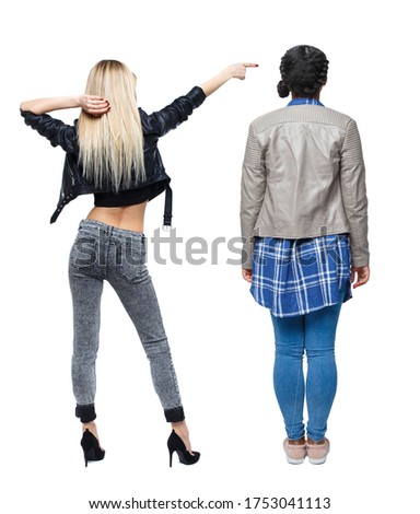 Back view of two pointing girl in winter jacket. Rear view people collection. backside view of person. beautiful woman friends showing gesture. Rear view. Isolated over white background.