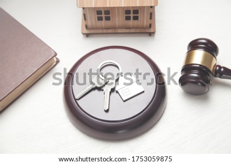 Judge gavel, house model, keys and book.