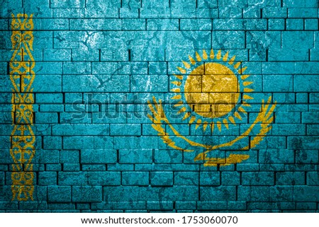 National flag of Kazakhstan on brick  wall background.The concept of national pride and symbol of the country. Flag  banner on  stone texture background.
