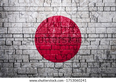 National flag of Japan on brick  wall background.The concept of national pride and symbol of the country. Flag  banner on  stone texture background.