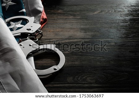 american flag and handcuffs on a wooden table