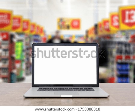 Modern computer,laptop with blank screen on table with blur supermarket