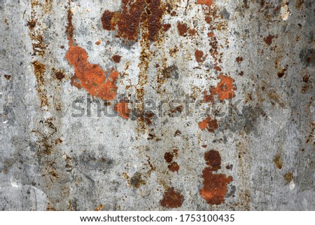 The surface of the metal sheet has a brown rust for the background.