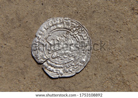 arab silver coin in the sand