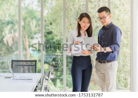 Entrepreneur Asian businessman and woman discussing new business project in tablet in modern meeting room Royalty-Free Stock Photo #1753132787