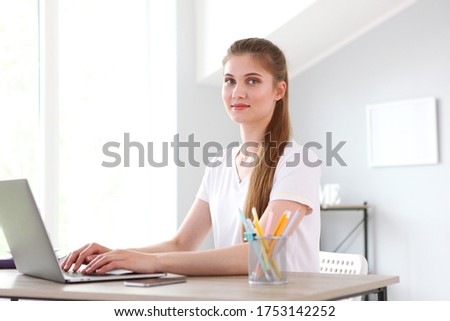 The girl works remotely from home using a modern laptop.

