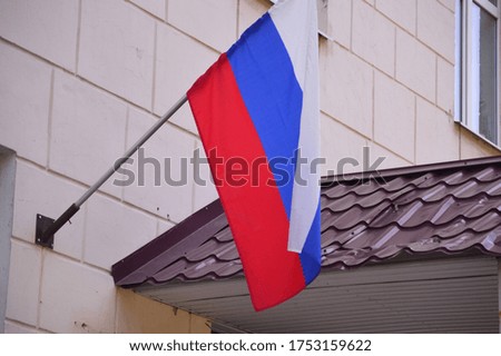 General view of the flag of the Russian Federation on a flagpole developing in the wind