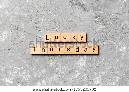 lucky thursday word written on wood block. lucky thursday text on cement table for your desing, concept.
