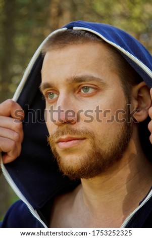 Handsome, young guy in a tracksuit plays sports in the park on the nature. Healthy lifestyle