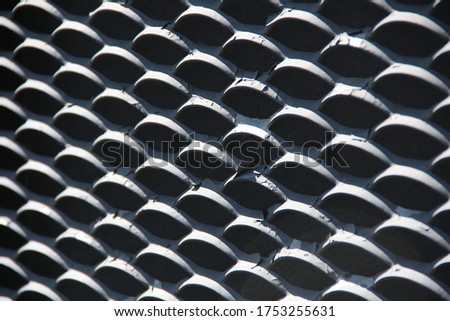 Pattern of an iron fence. Iron curls of the fence lattice illuminated by the sun. Backgrounds.