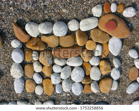 Beautiful background with a sunny composition of multi-colored stones in the form of a horse on the seashore.