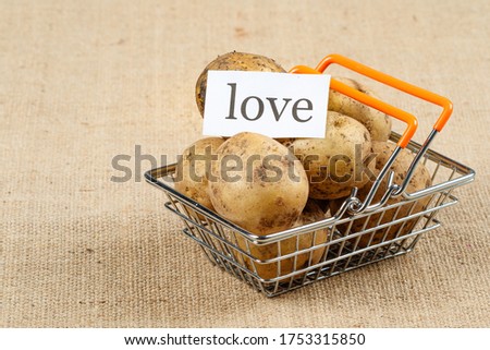 potatoes in a toy basket from the supermarket on it the inscription love. those who like to eat potatoes