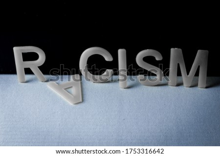Drop racism, word written with letters on a two-tone background, the second letter fell. Concept against racism.