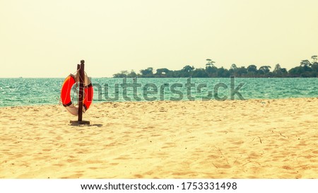 Empty tropical beach background. Horizon with sky and white sand. Beach landscape. Summer landscape with lifebuoy and palm leaves for beach banner. Author's space. Large space for inscription or logo