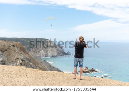 photographer taking images of paragliders from a cliff