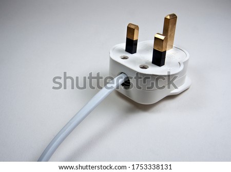 3 pin UK standard plug unplugged on plain white grey background with white cable with wiring diagram
