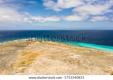 Aerial view of coast of Klein Curacao in the Caribbean Sea with turquoise water, cliff, beach and beautiful coral reef