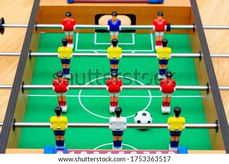 Close up table soccer with red yellow players and a ball.Blurry background.