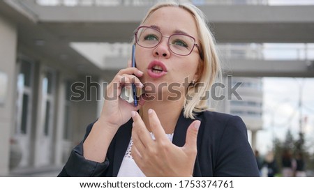 Entrepreneur on a mobile phone works while talking on a smartphone. Attractive blonde talking on the phone