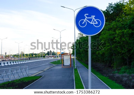 Road sign bicycle path on the background of a grove, alley, highway