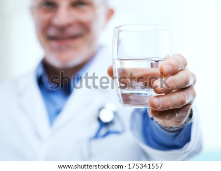 Doctor offering a glass of water, healthy lifestyle concept. Royalty-Free Stock Photo #175341557