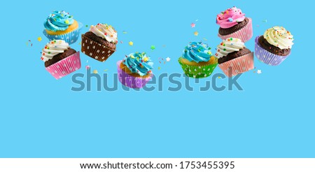 Delicious Cupcakes for party, birthday. Various cupcakes with pink white and blue cream flying over blue background