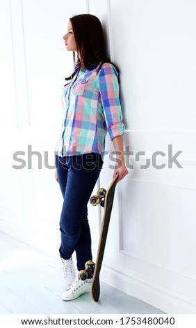 Cute, attractive teenager with skateboard