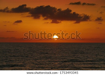 A picture of the sun setting in the beach in Israel.