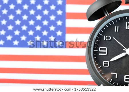 Close up of retro analog clock on USA american flag background.