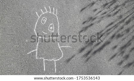 simple doodle little man drawn in chalk by a three year old child on the pavement