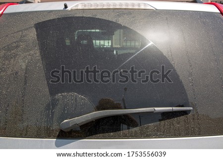 back window of a dirty car covered in dust in a dry mud rear view of a 4x4 suv car, close up nobody.