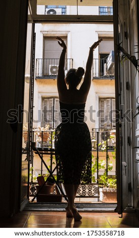 Beatiful woman waiting anda dancing in front of her balcony.