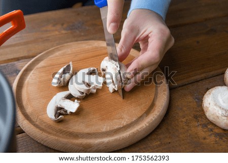 slicing champignon mushrooms for cooking