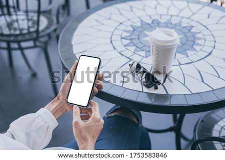 cell phone mockup image blank white screen.woman hand holding texting using mobile on desk at coffee shop.background empty space for advertise.work people contact marketing business,technology