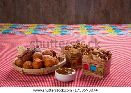 Brazilian june party celebration, with typical sweets, cake, on checkered cotton tablecloth.