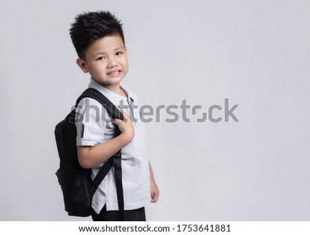 Smart little asian boy with backpack having fun. School concept. Back to School