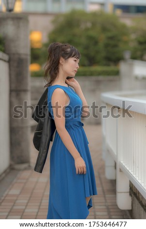 Japanese woman beside the parapet at sunset