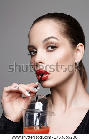 beautiful girl drinking cocktail. young brunette woman with make-up holding glass