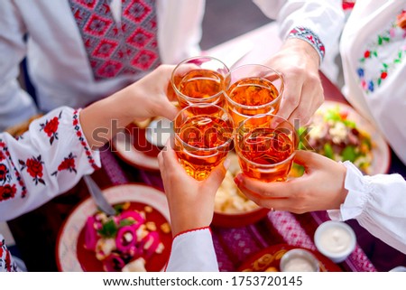 Ukrainian birthday party. Family in traditional clothes has dinner together. Ukrainian culture and Ukraine concept. Holiday concept. Family eating and clang glasses together. Banner.