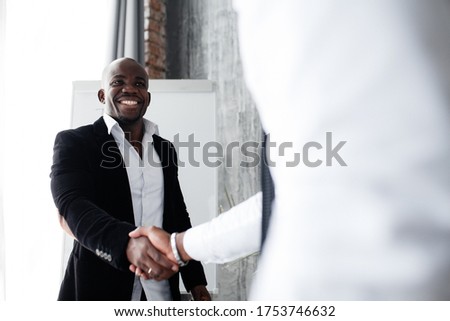 Black African American in a suit smiles and shakes hands with his new investor in the conference room Royalty-Free Stock Photo #1753746632