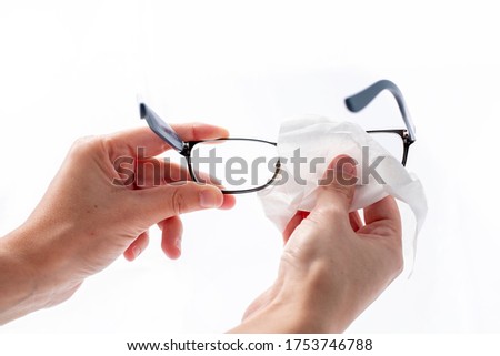woman cleaning glasses with an alcohol-disinfecting antibacterial wipe as a prevention to kill bacteria and viruses Royalty-Free Stock Photo #1753746788