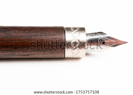 A close-up product shot of the wooden barrel and writing tip of a classic fountain pen set on plain white background.