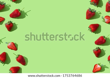 Colorful pattern red strawberries on green pastel background with copy space for text. Summer berries. Trendy Wrapping paper, poster, greeting card, cover, market, grocery store, sale background.