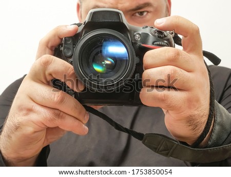 photographer taking a photo with digital 50mm lens reflex camera.Man taking photo of you with mirror camera. photographer with lens in hand on blue background. close-up camera.focus on lens